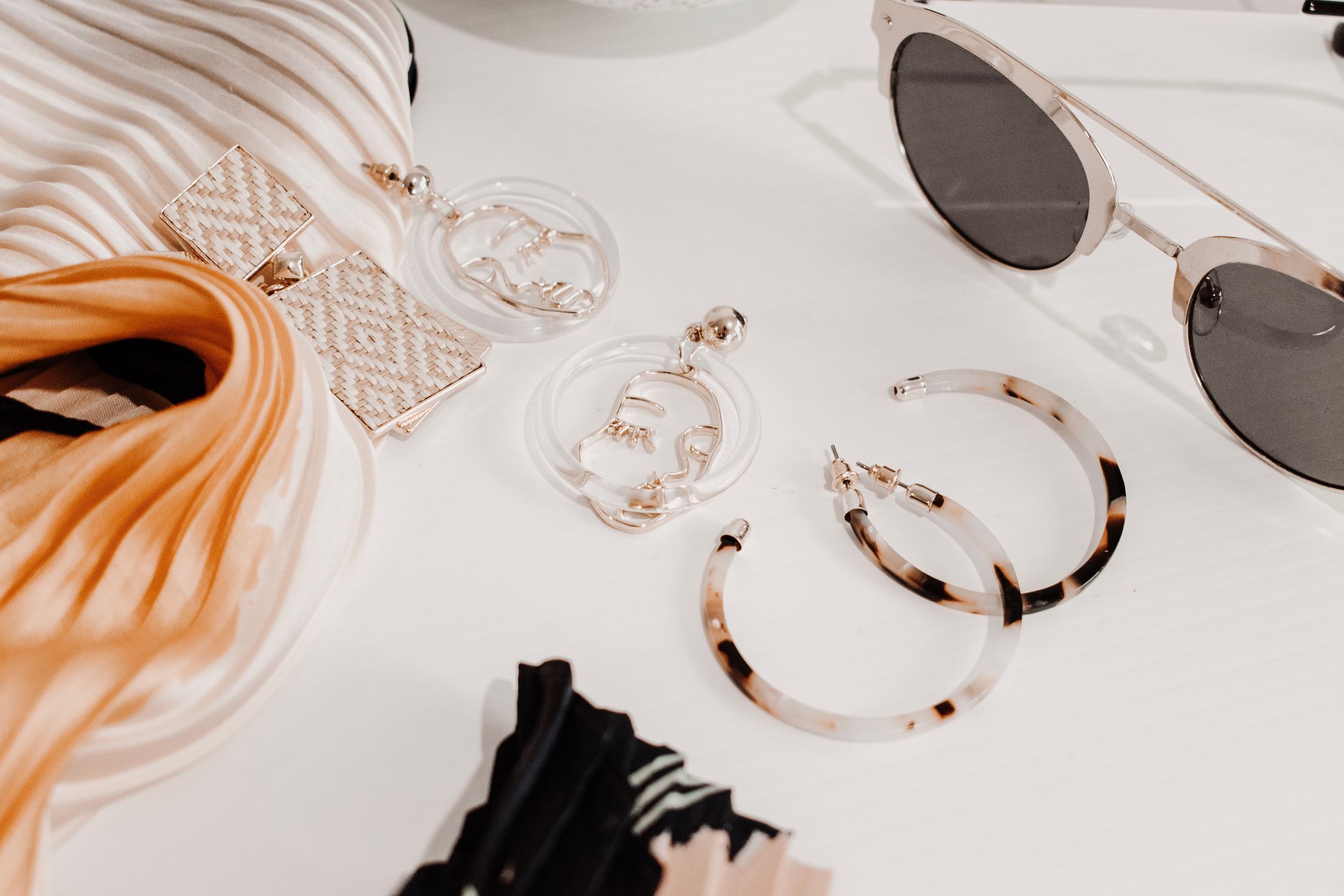 Accessories and a silk scarf on a light surface