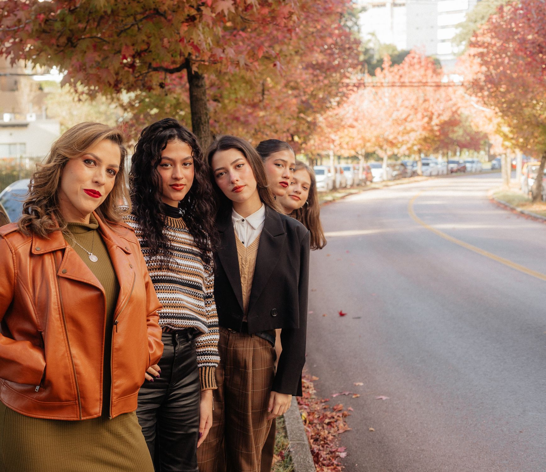 Friends wearing layered city outfits on an autumn street